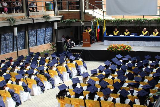 Graduandos con toga y birrete en ceremonia de graduación de UNIMINUTO seccional Antioquia - Chocó.