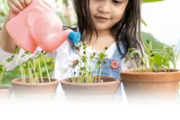 niña regando plantas