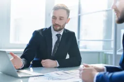 Hombres en mesa de trabajo revisando documentos