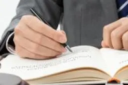 persona escribiendo en una mesa con un mazo