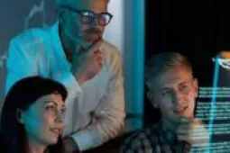 Tres personas mirando pantala digital