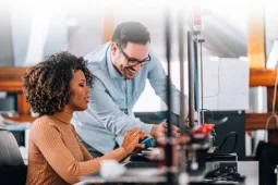 Una mujer y un hombre trabajan juntos en un ambiente de oficina moderna