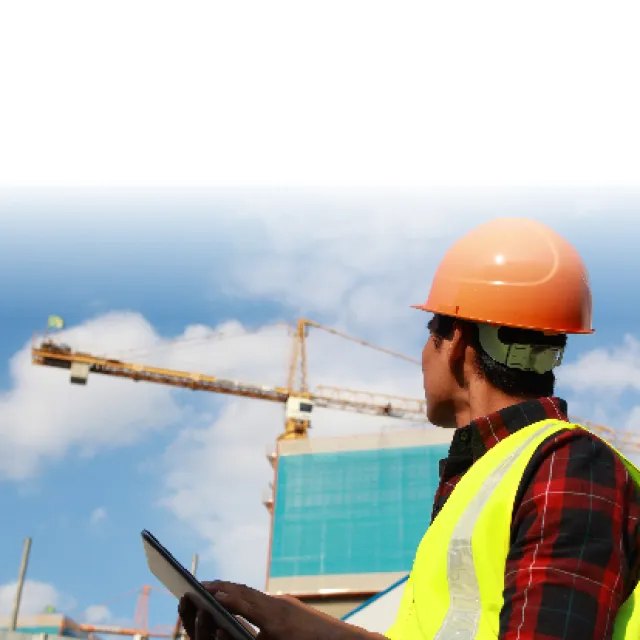 obrero con casco en construcción con grúa de fondo