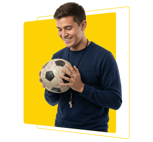 Hombre entrenador sosteniendo balón de fútbol y sonriendo en contexto de educación física, deporte y formación integral